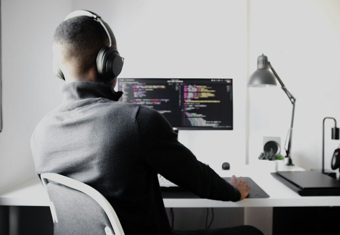 A developer wearing headphones writing code at a desk
